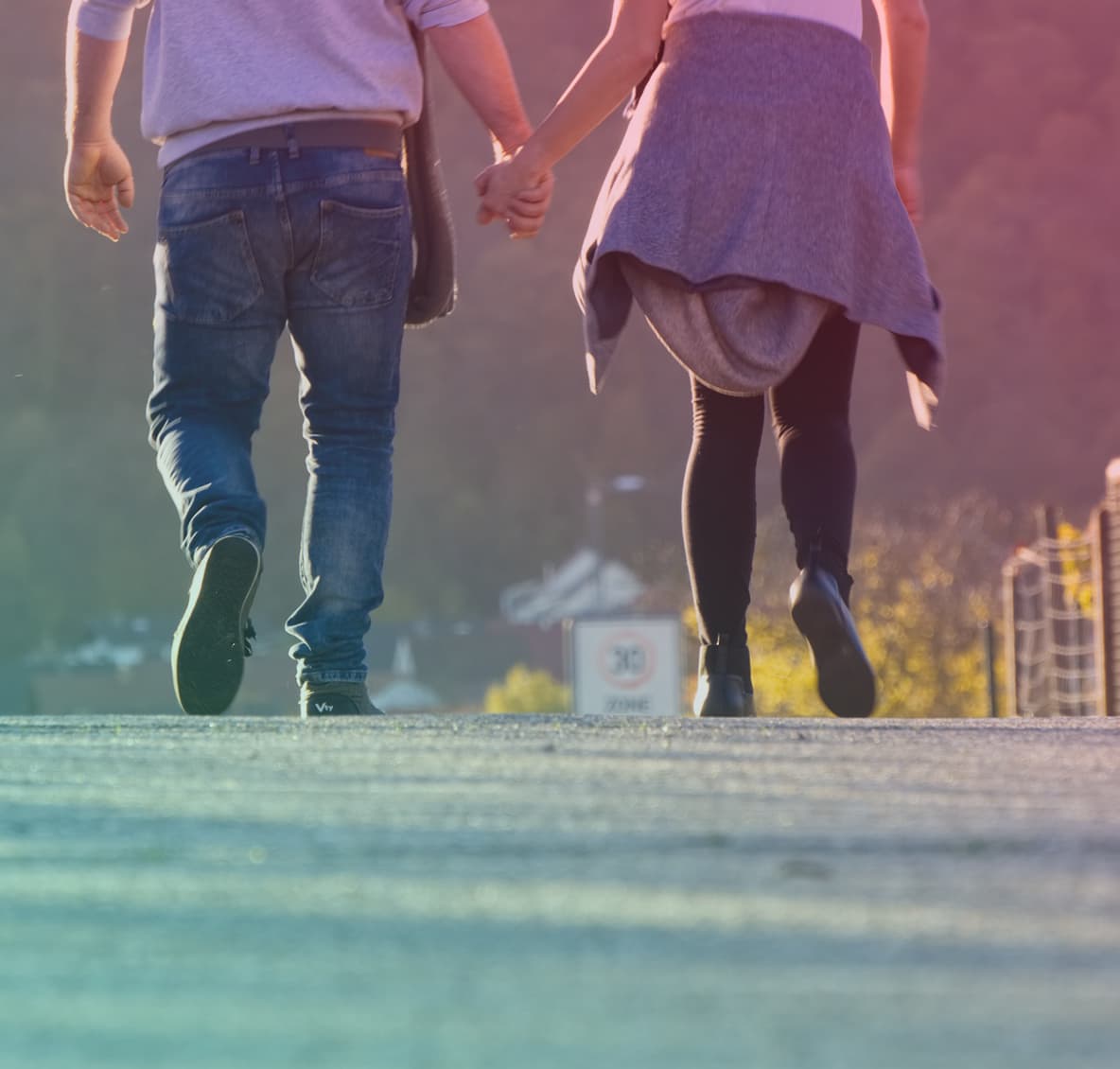 A couple walking down a road holding hands